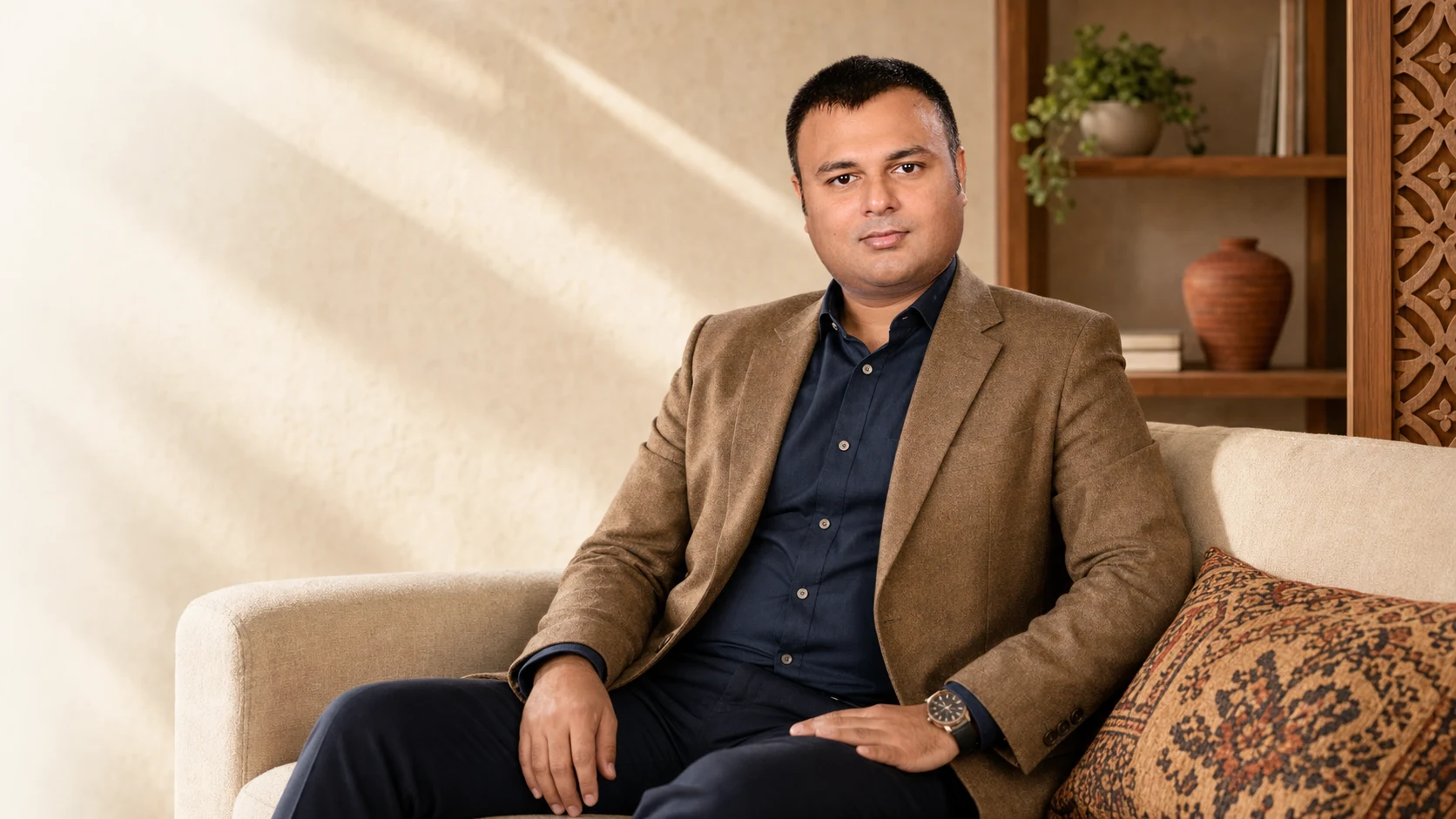 Shiraz Qamar seated on a sofa in a warm founder office
